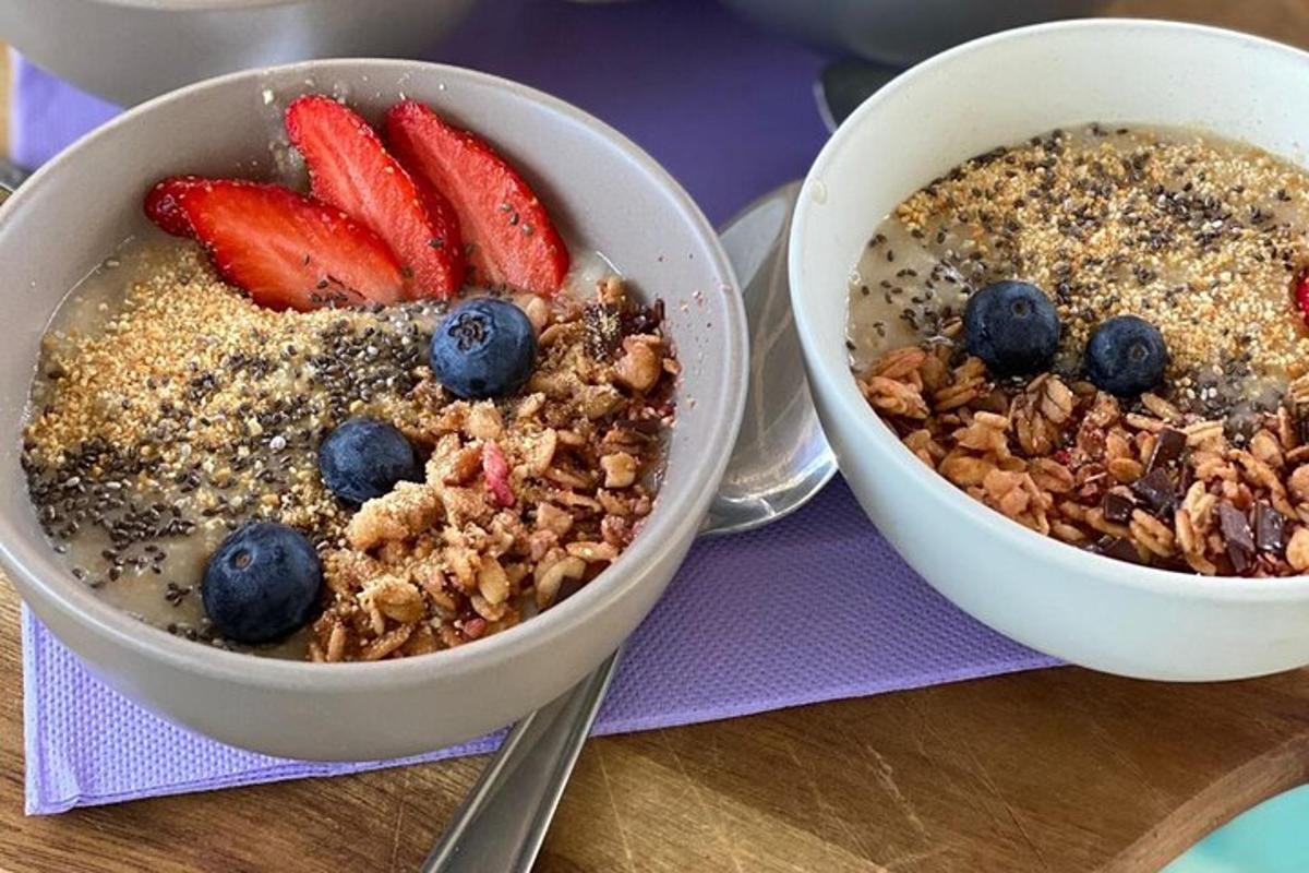 two bowls of cereal and fruit on a table