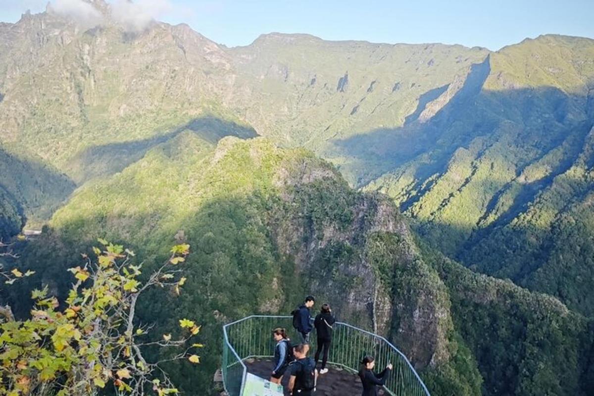 um grupo de pessoas em pé em uma plataforma de observação em uma montanha