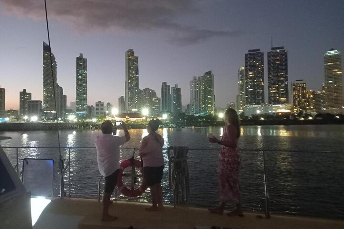 three people standing on a boat looking at the city