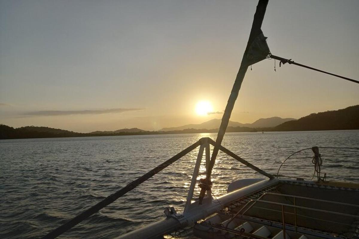 a boat on the water with the sun in the background