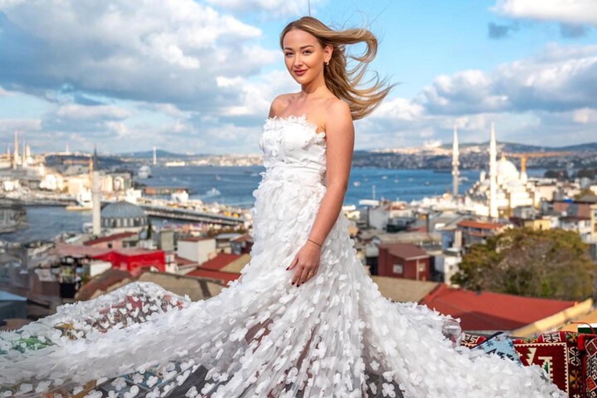 una donna in abito bianco in piedi in cima a un edificio