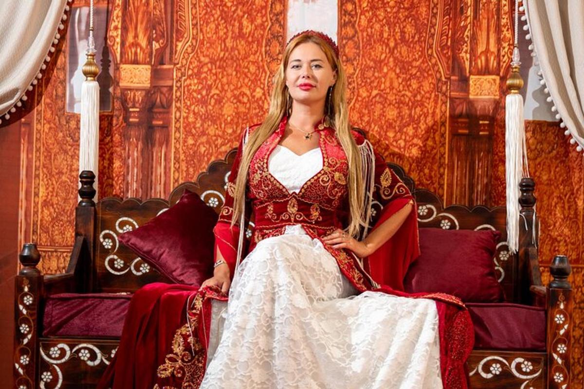 una donna seduta su una sedia con un vestito rosso e bianco
