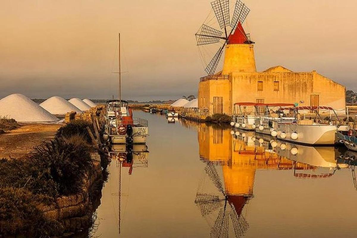 bygging með vindmyllu og bátum í vatninu