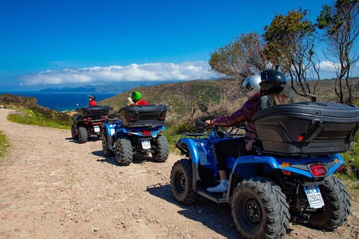 three people riding on atvs on a dirt road