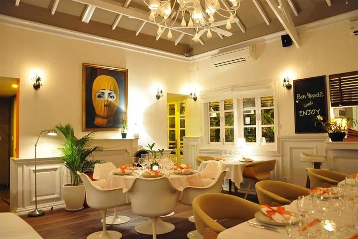 restaurace s bílými stoly a židlemi a lustrem