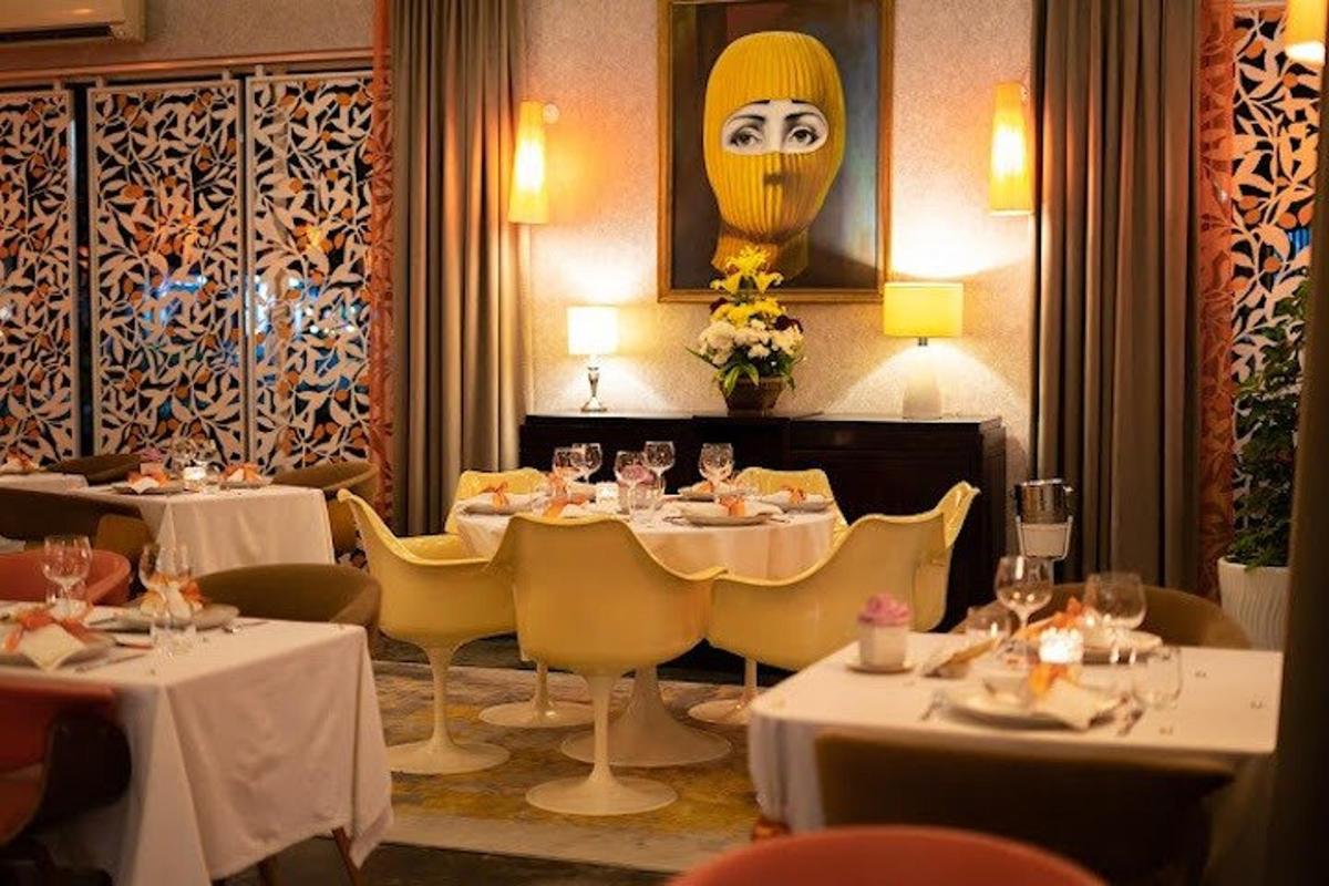 restaurace se stoly a židlemi a tváří na zdi