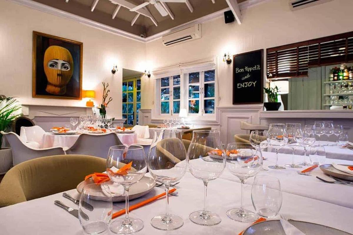 restaurace s bílými stoly a židlemi a sklenicemi na víno