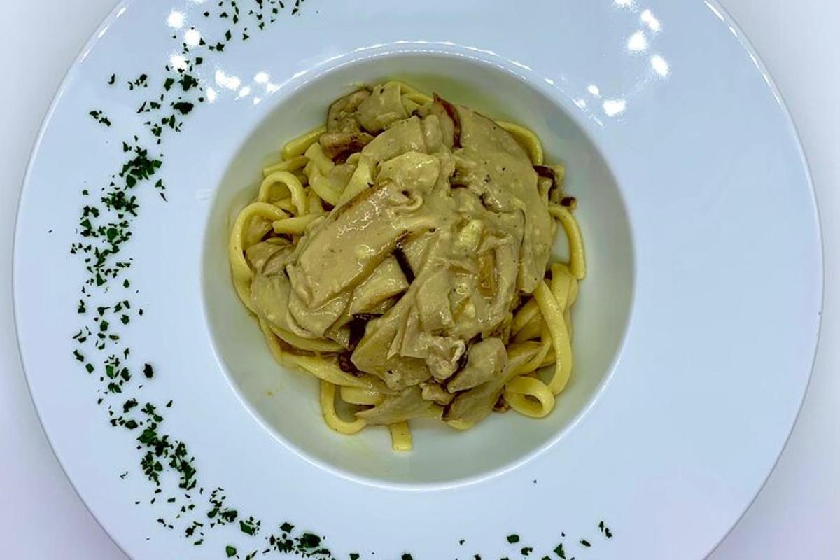 en skål pasta med kött och sås på en tallrik