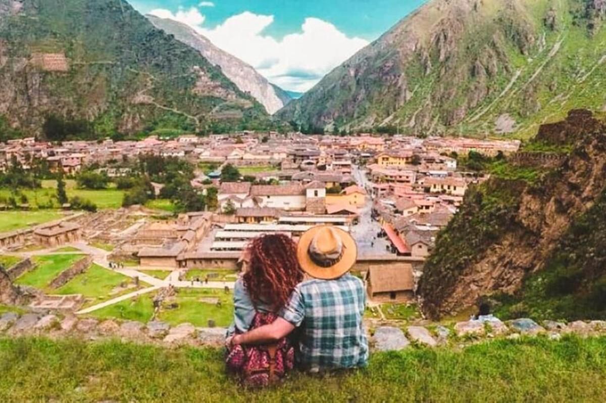 due persone sedute su una collina che guardano una città