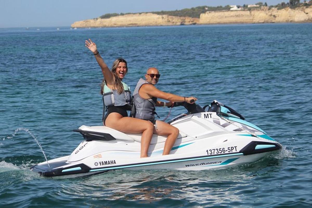 en mann og en kvinne som kjører på en jetski i vannet