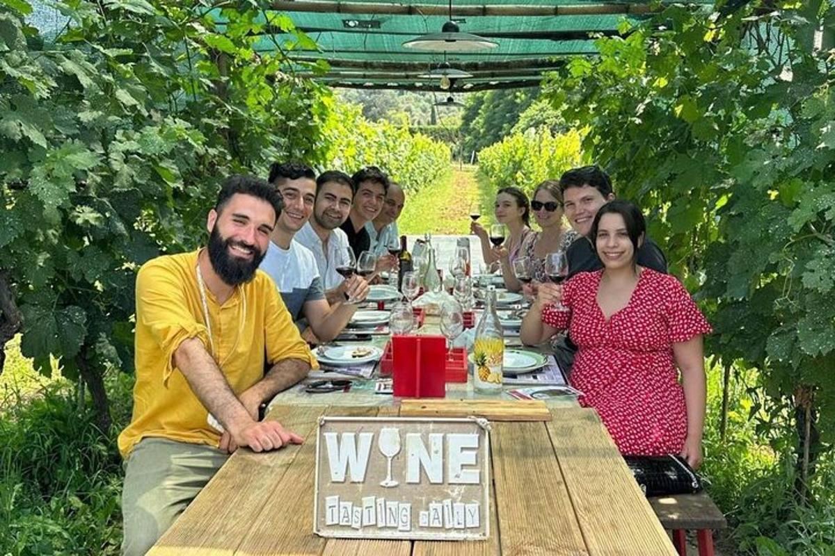 grupa ludzi siedząca przy stole z kieliszkami wina
