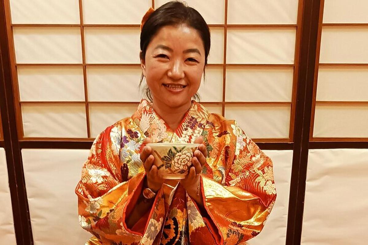 una donna in kimono che tiene in mano una tazza