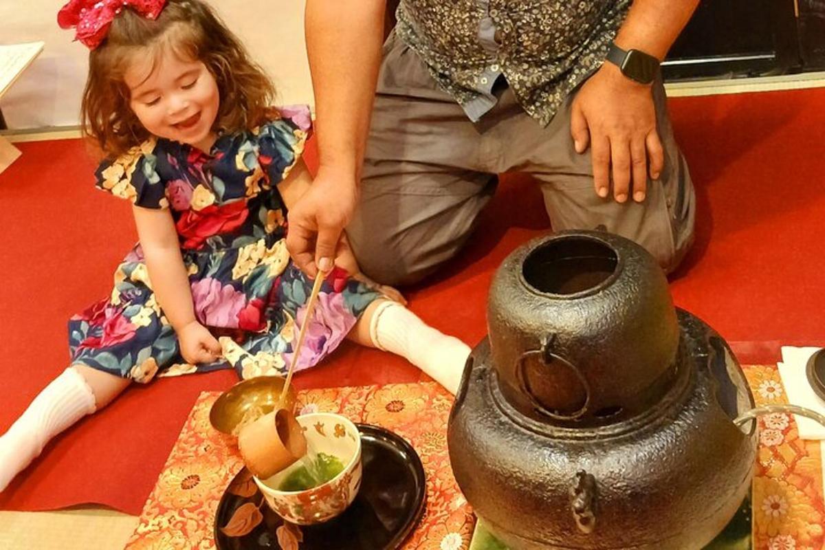 una bambina seduta sul pavimento accanto a un vaso