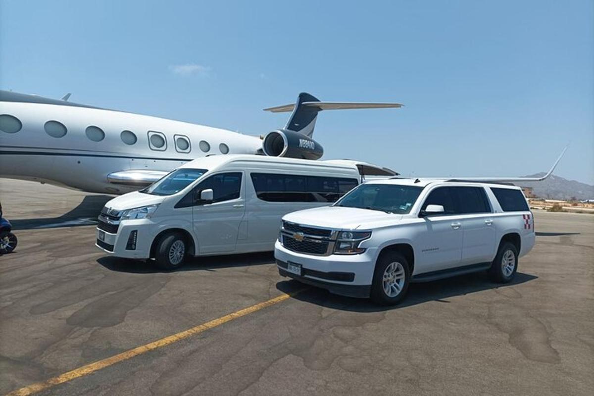 two vehicles are parked next to an airplane