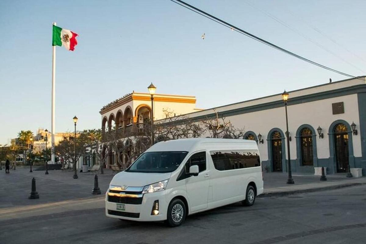 uma van branca estacionada em frente a um prédio