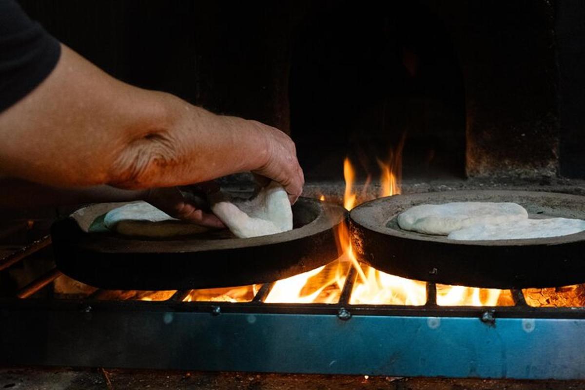 osoba vařící jídlo na pánvích na grilu