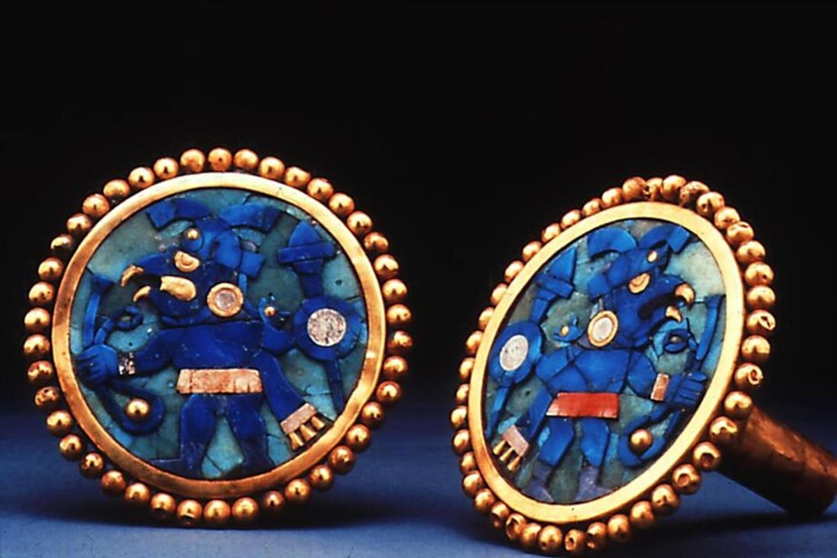a pair of earrings with a painting of a person