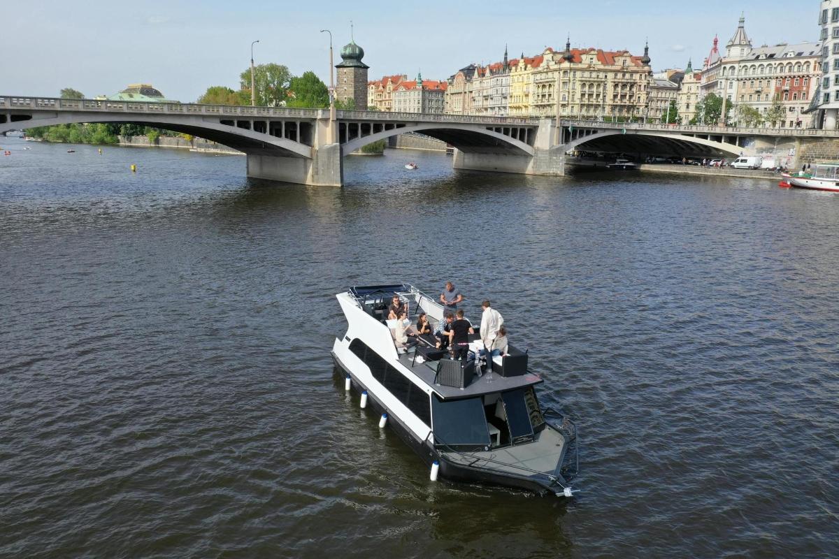 um grupo de pessoas em um barco na água perto de uma ponte
