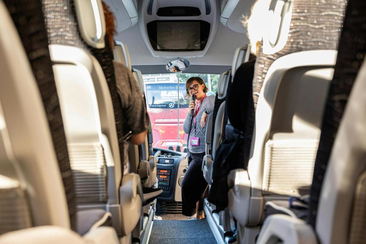a woman standing in the middle of the inside of a bus