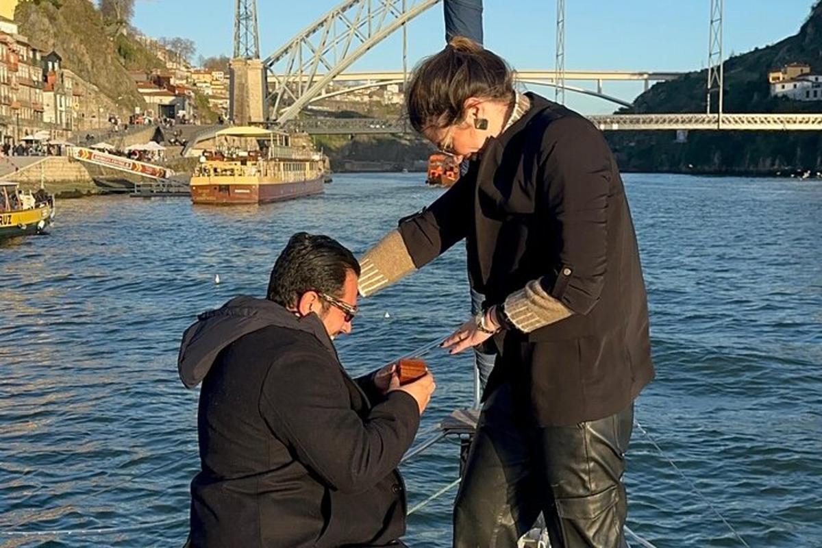 Δύο άντρες στέκονται δίπλα στο νερό κοιτάζοντας ένα κινητό τηλέφωνο