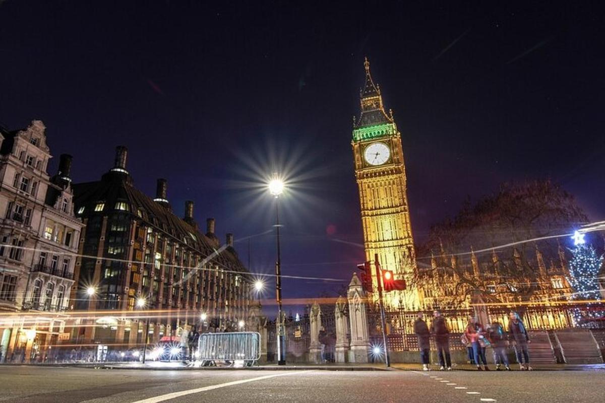 một tháp đồng hồ cao với đồng hồ Big Ben vào ban đêm