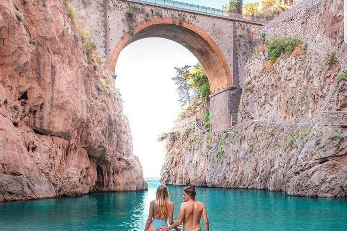 due persone che camminano nell'acqua sotto un ponte