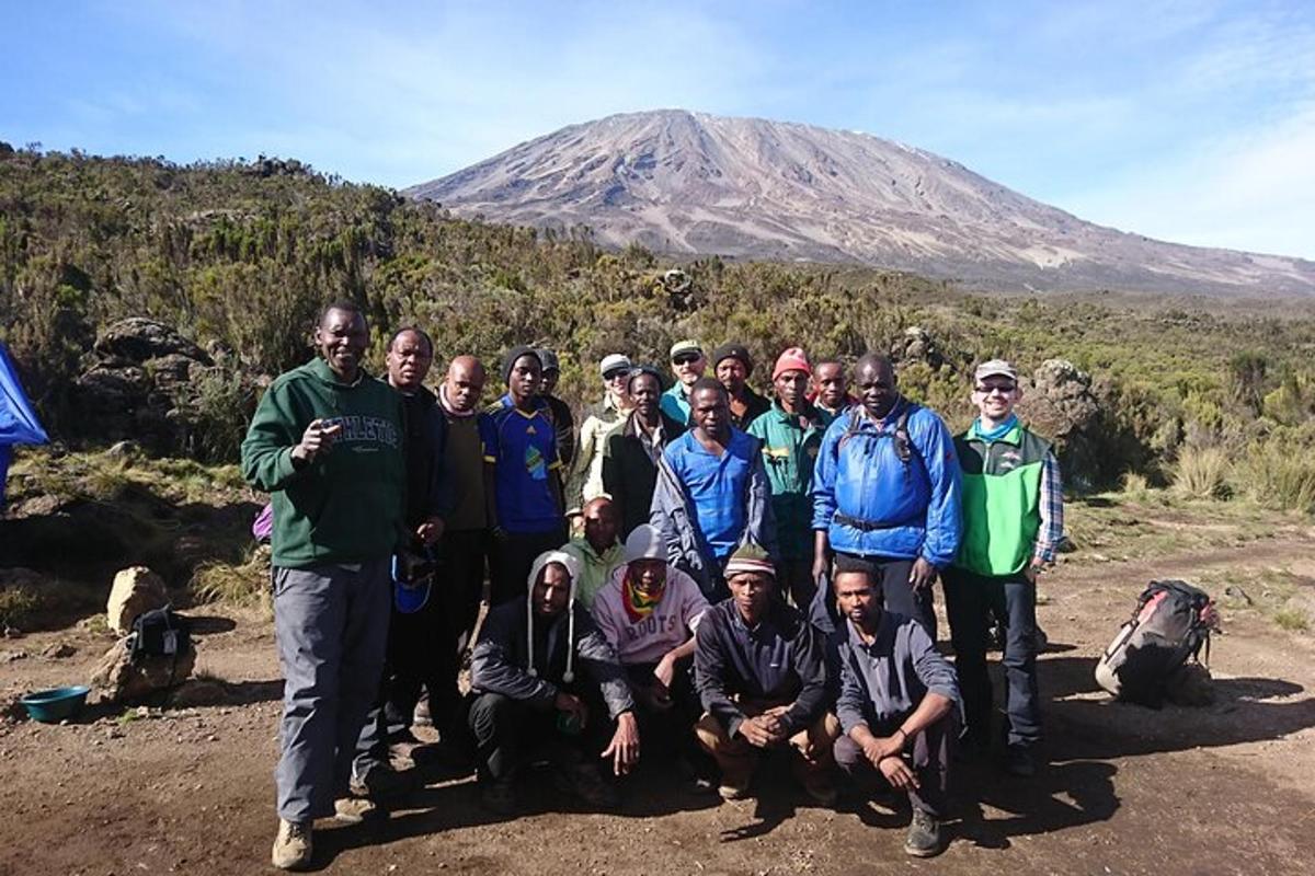 un gruppo di persone in posa per una foto davanti a una montagna