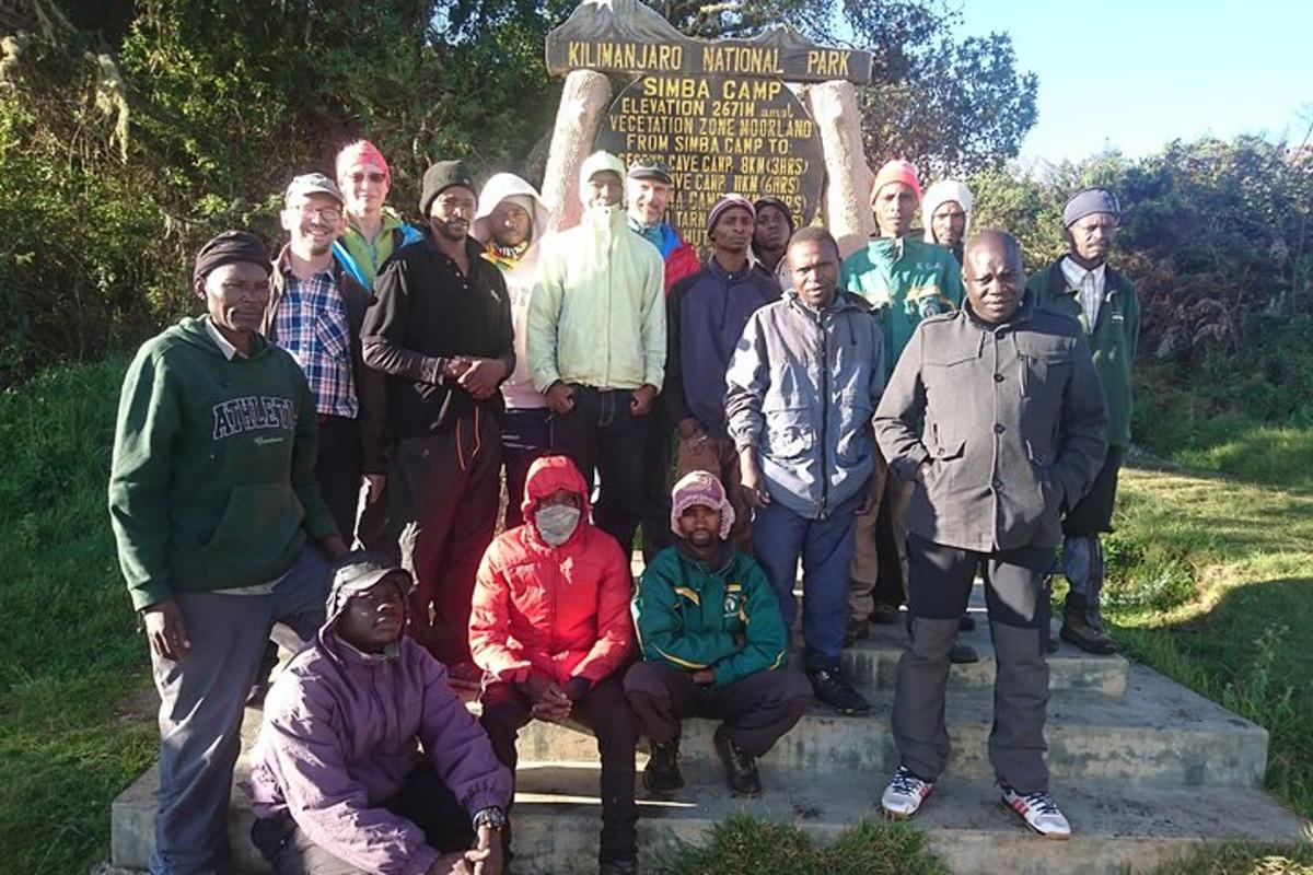 un gruppo di persone in posa per una foto davanti a un cartello