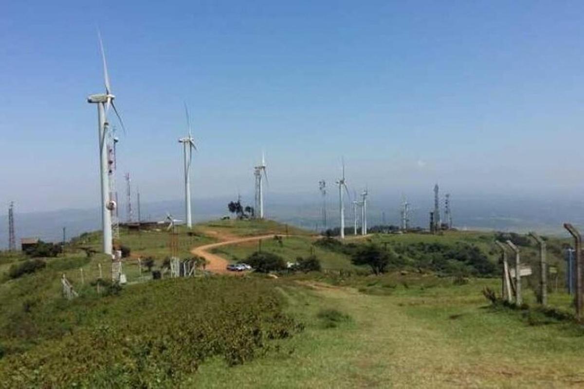 ένας χωματόδρομος στην κορυφή ενός λόφου με ανεμογεννήτριες