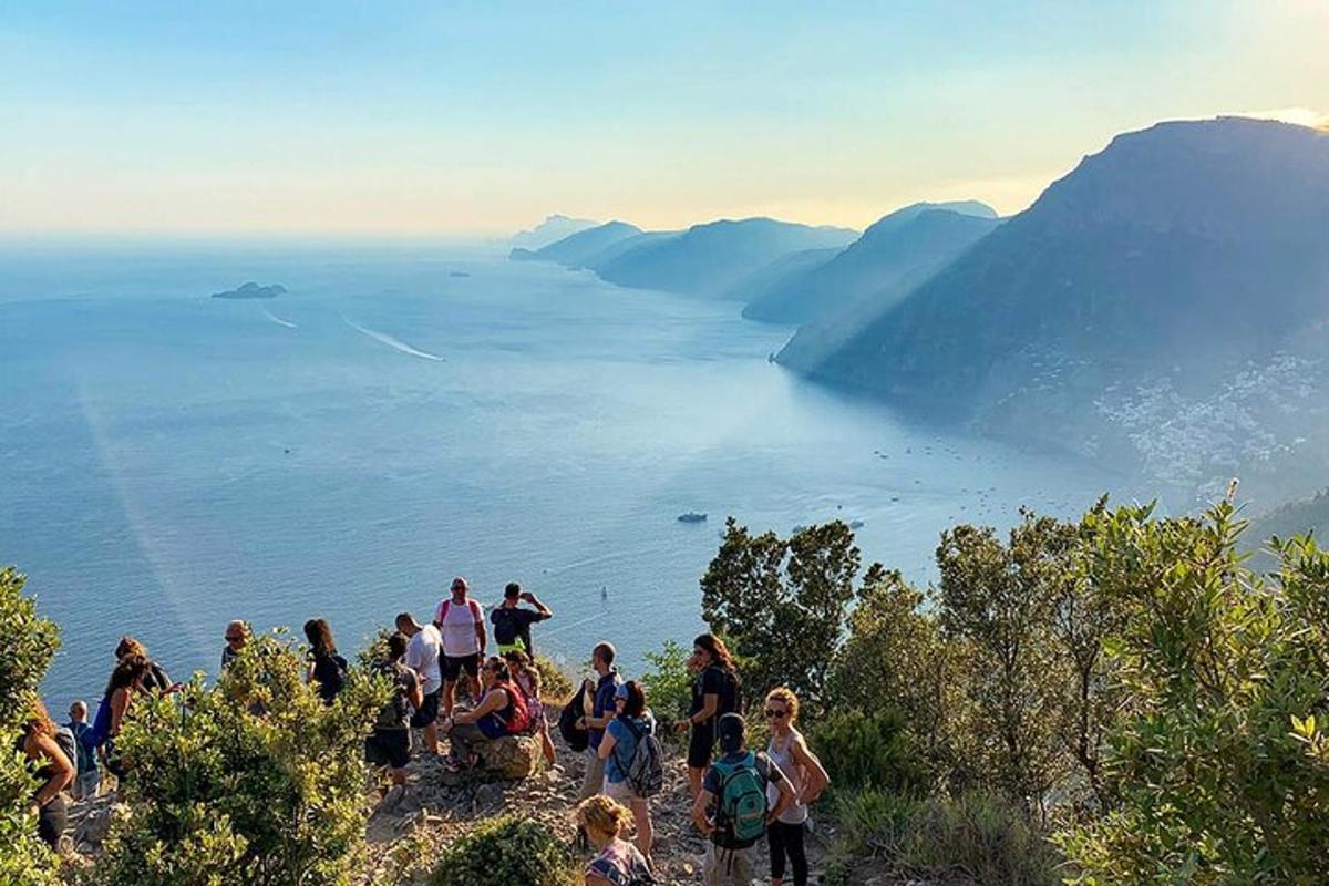 un gruppo di persone in piedi su una collina che domina l'acqua