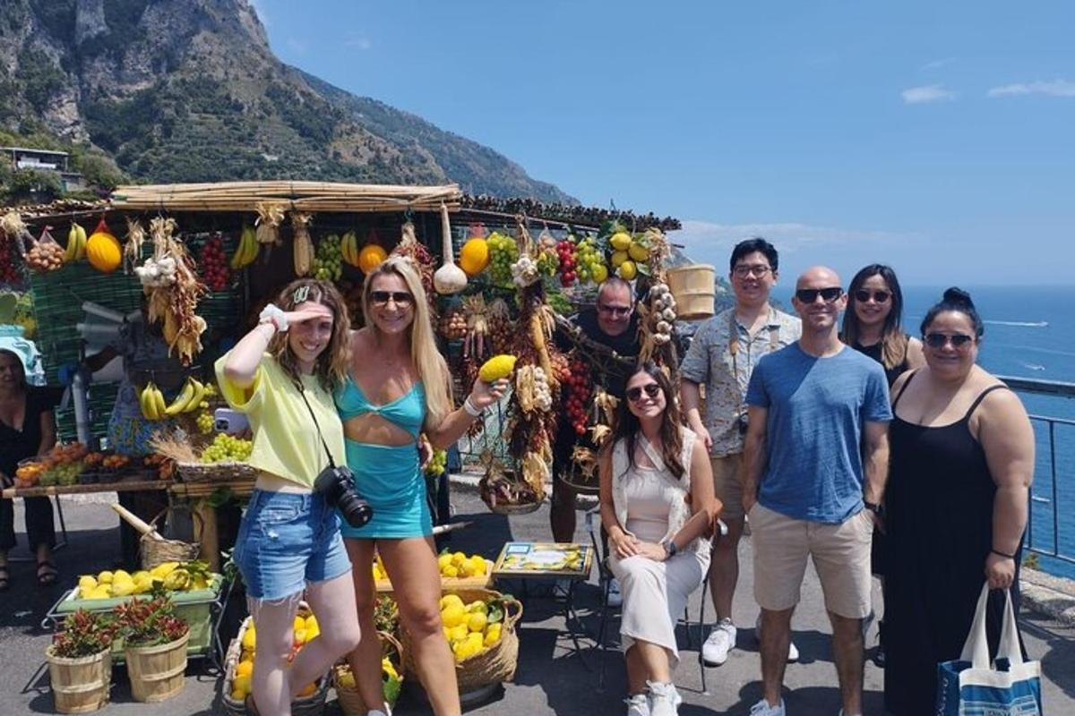 un grup de oameni care stăteau în fața unei tarabe cu fructe