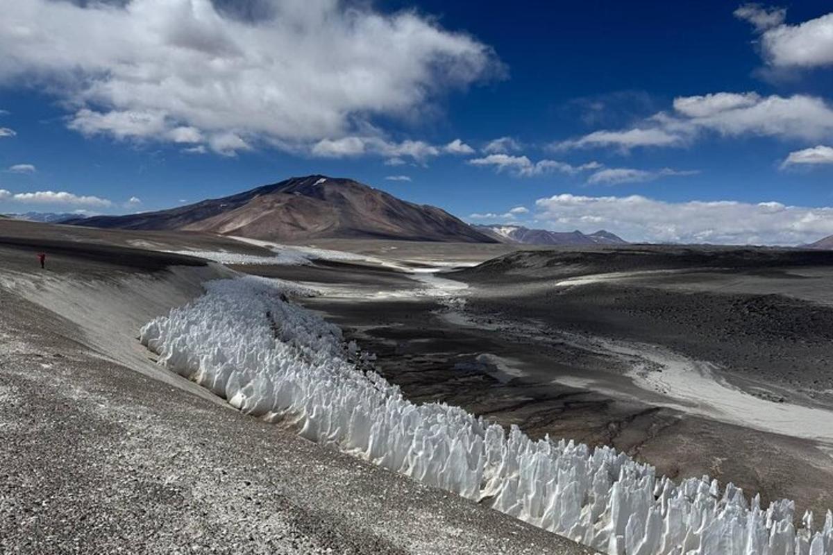 a mountain in the middle of a desert with snow