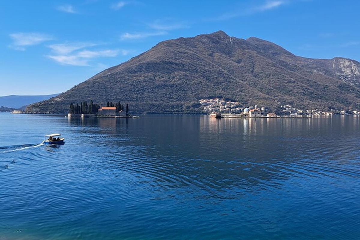 μια μικρή βάρκα σε ένα μεγάλο υδάτινο σώμα με ένα βουνό