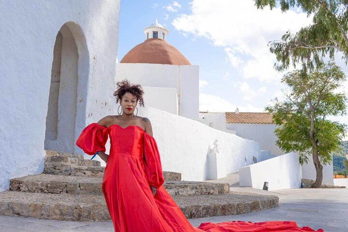 a woman in a red dress standing in front of a building