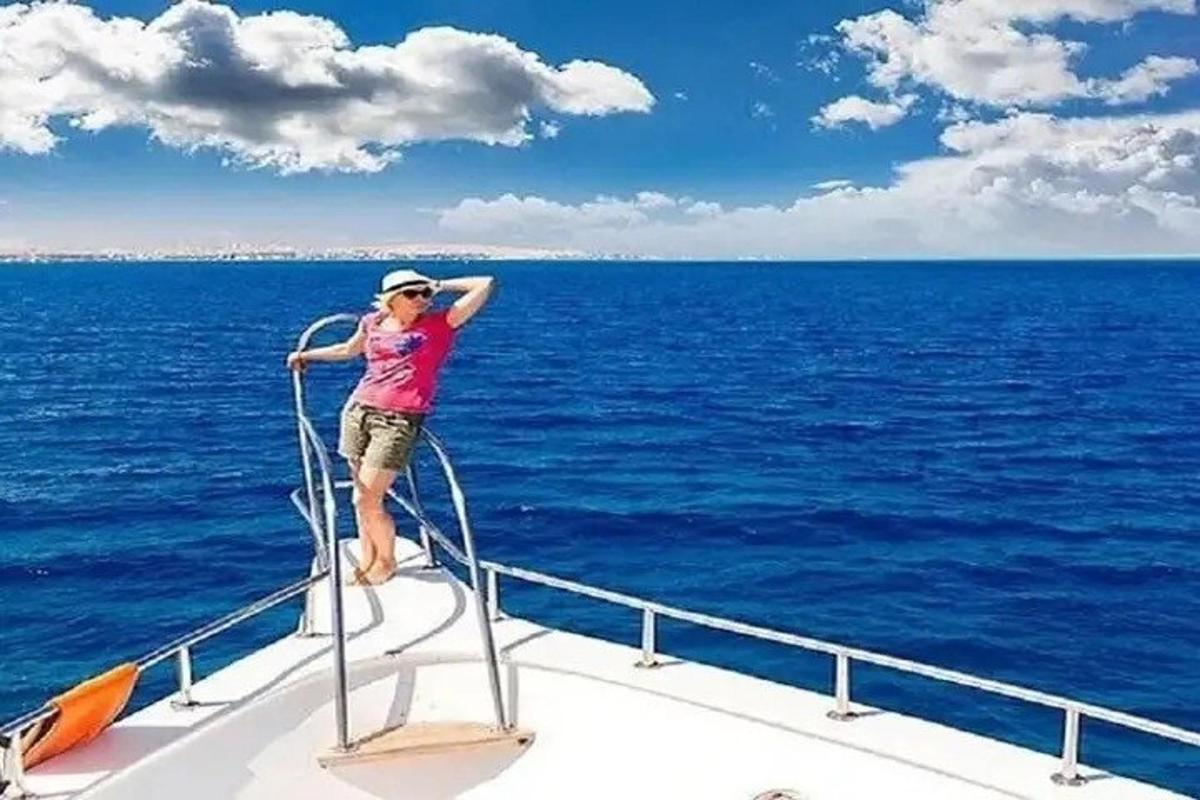 nainen seisoo veneen keulassa meressä