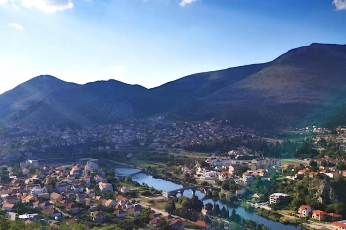 a view of a town with a river and mountains