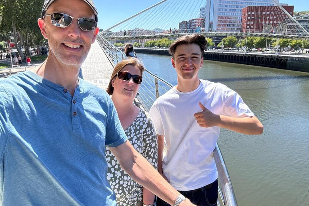 two men and a woman standing next to a river