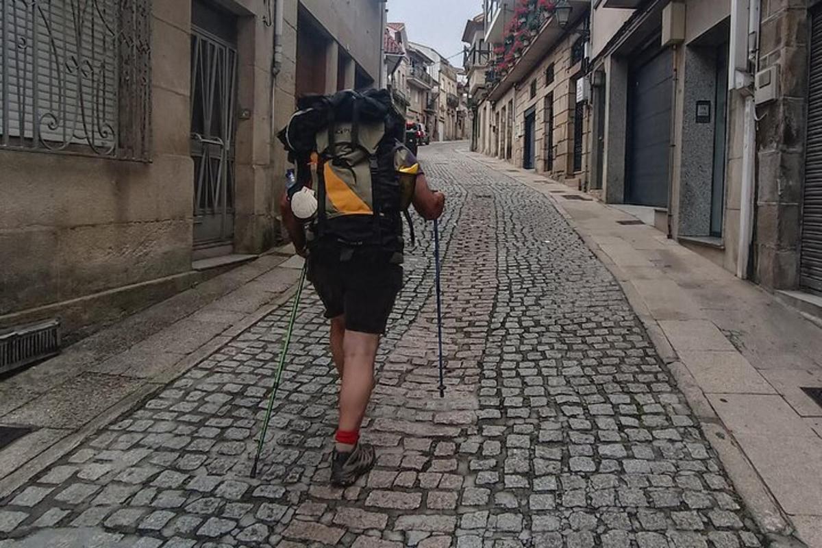 člověk jdoucí po ulici s batohem na zádech