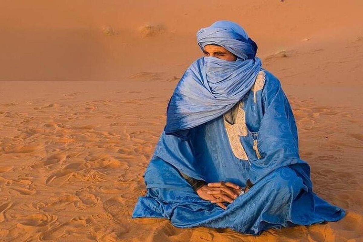 eine Frau, die im Sand in der Wüste sitzt
