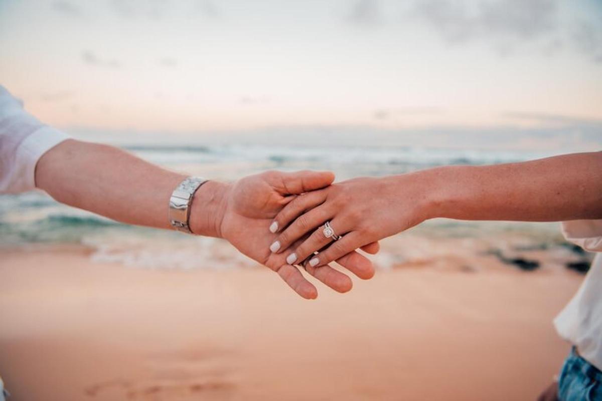 um casal de mãos dadas na praia
