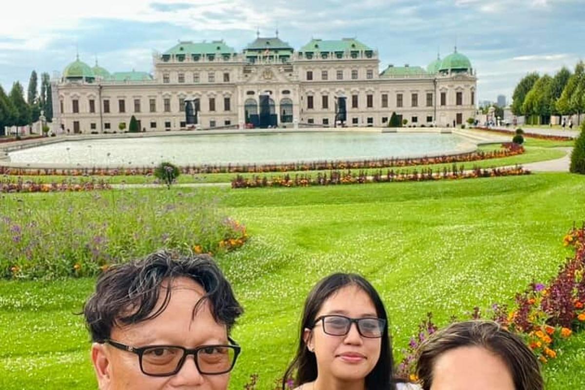 three people standing in front of a large building