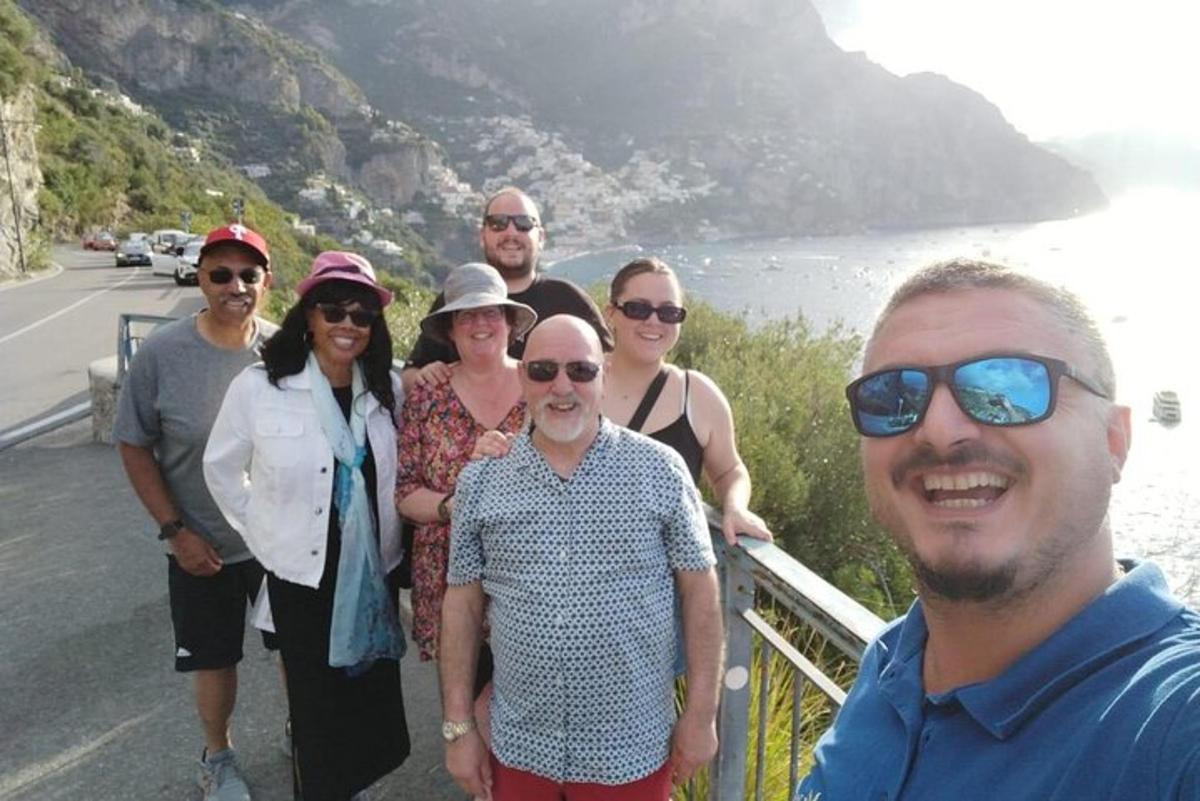 a group of people standing on the side of a road