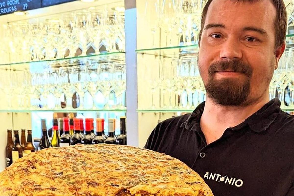 en mand holder en stor pizza i en butik