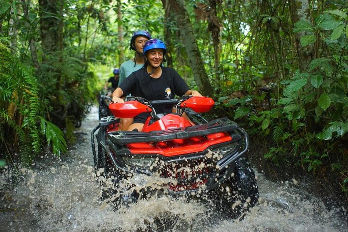 due persone che viaggiano su un veicolo a quattro ruote attraverso un fiume