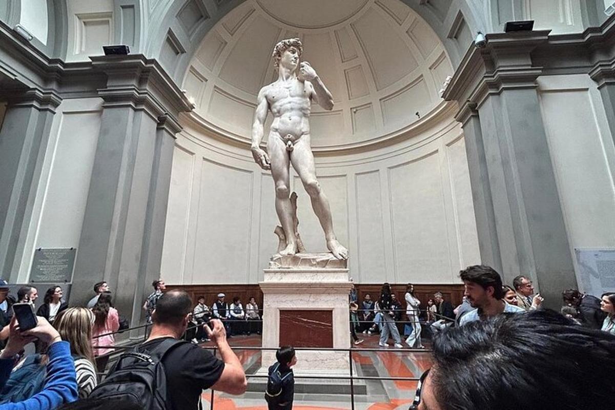 una folla di persone che scatta foto di una statua in un museo
