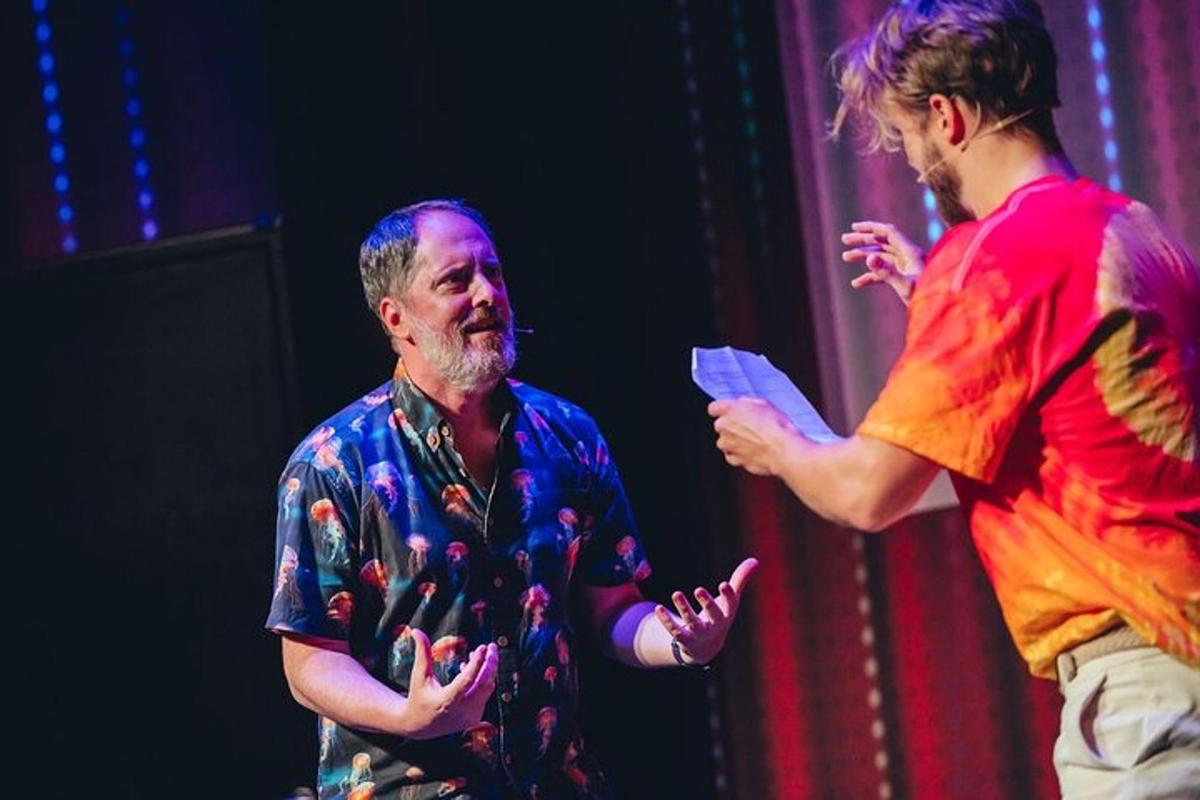 a man standing next to a man on a stage