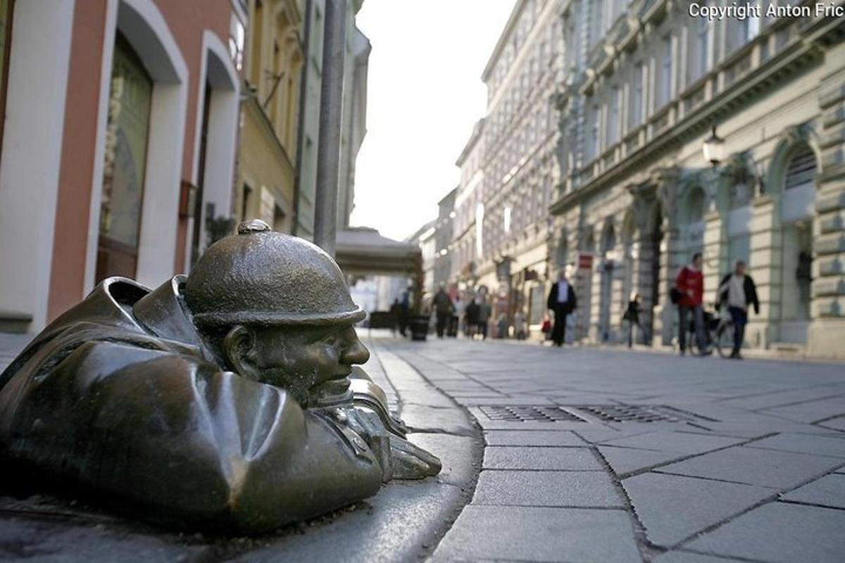 a bronze statue of a man sitting on a street