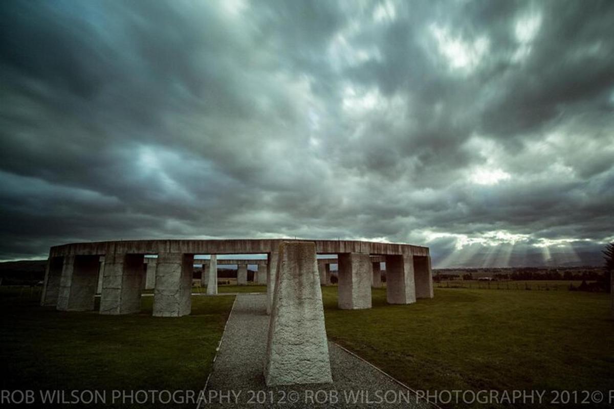 un edificio in un campo sotto un cielo nuvoloso