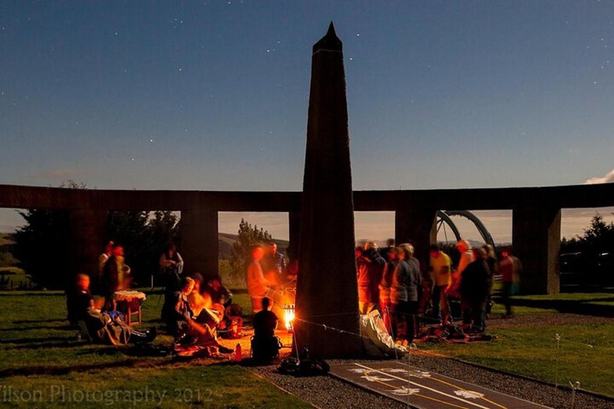 a group of people standing around a camp fire