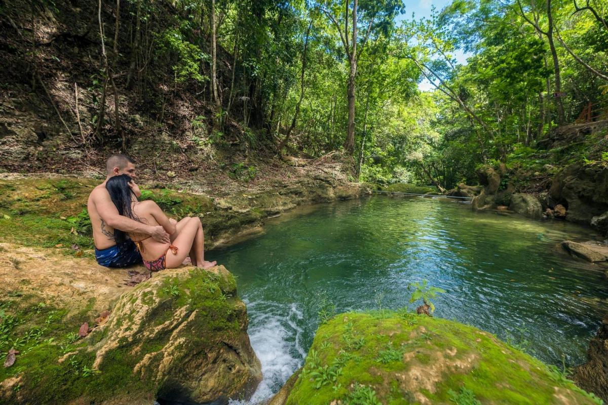 een man en een vrouw zitten op een rots bij een rivier